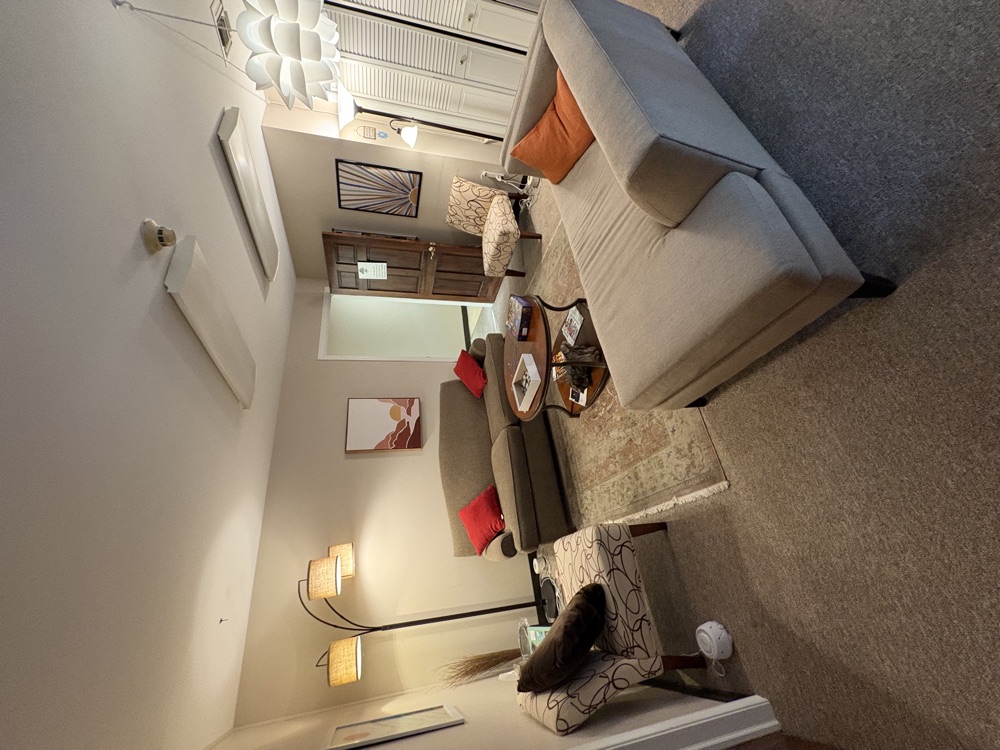 The office lounge — soft seating, warm lamplight, and calming artwork